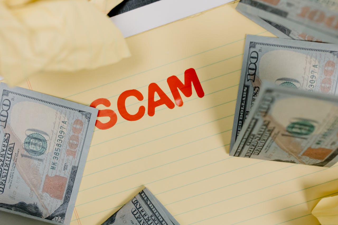 about-us Conceptual image of financial scam with US dollars on yellow paper and word 'scam' visible.